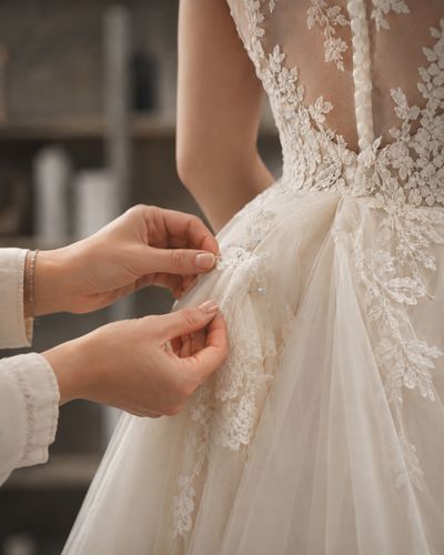 Lace and tulle pinned at the waist of an ivory bridal gown